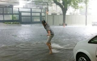 Em meio a temporal, Ashton Kutcher &quot;surfa&quot; nas ruas de São Paulo