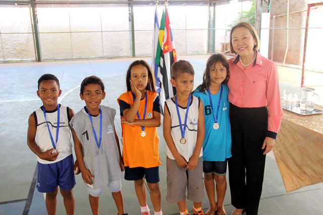 Tamiko entrega medalhas e troféus da competição de atletismo entre escolas municipais que promoveu o espírito olímpico. Foto: Divulgação/Prefeitura