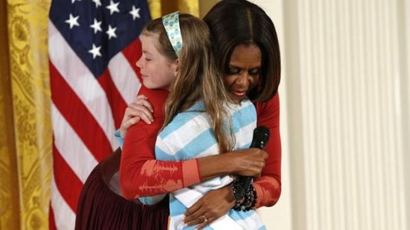 Michelle Obama abraça Charlotte Bell, de 10 anos de idade, que entregou à primeira-dama o currículo do pai desempregado (Kevin Lamarque/Reuters)