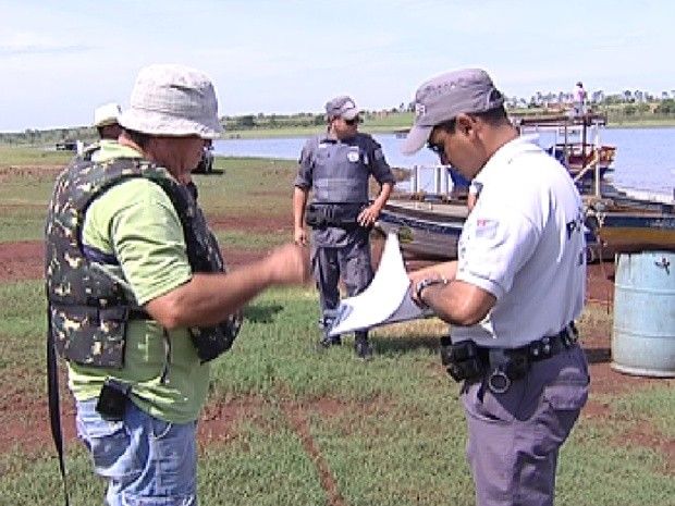 Policial fiscaliza pescador durante blitz no rio Grande (Foto: Reprodução / TV Tem)