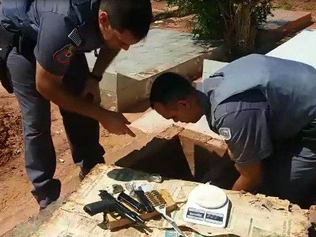 Policiais retiram drogas e arma de túmulo (Foto: Divulgação/Polícia Militar)