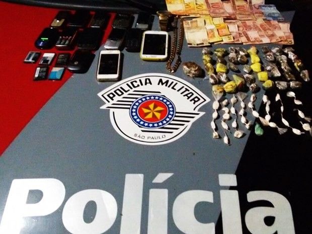 Jovem foi detido com drogas, dinheiro e celulares (Foto: Divulgação / Polícia Militar)